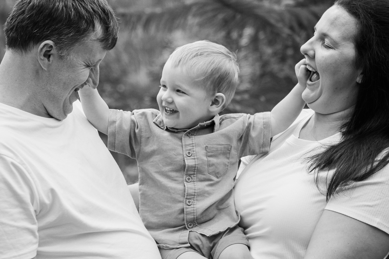 Family enjoying a playful moment outdoors, captured by professional photographer in Ipswich for lifestyle portraits.